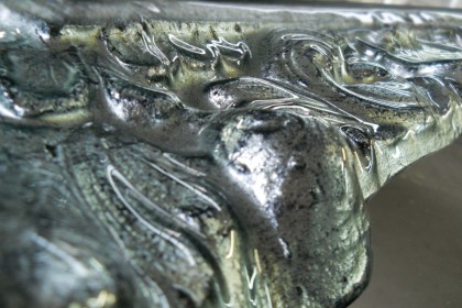 Particolare di specchiera in fusione decorata in foglia argento antiquato smal